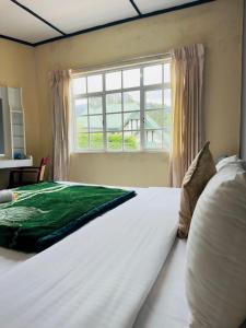 un grande letto bianco in una camera da letto con finestra di Grand Nauro villa a Nuwara Eliya