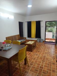 a room with a table and chairs and a table and a table and chairs at Osprey individual Cottage in Ooty