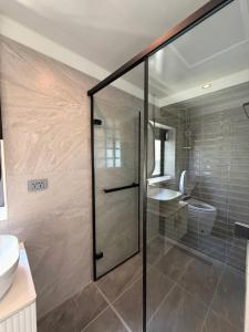 ein Badezimmer mit Glasdusche und Toilette in der Unterkunft Nancheng Renlan in Anping + 26 Fotos