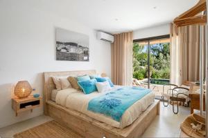 a bedroom with a large bed with blue pillows at Villa Carlina - Saint Tropez in Sainte-Maxime