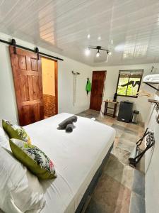 a bedroom with a large white bed in a room at Boutique Rooms River Front at La Junta in Dominical