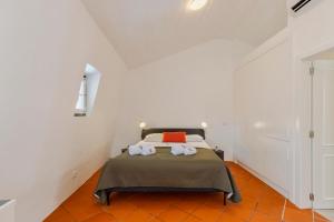 a bedroom with a bed in a white room at Sapalinho Retreat - By Y Concept in Setúbal