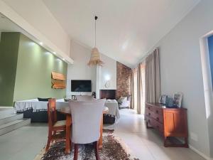 a living room with a table and a bedroom at Harris Estate Country Home in Ballito