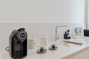 a coffee maker and two cups on a counter at Sapalinho Retreat - By Y Concept in Setúbal
