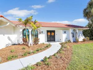 フォートマイヤーズにあるRelax at Lake Breeze 4BR Fort Myers Getawayのヤシの木と歩道のある白い家