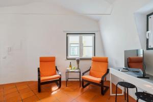 a room with two orange chairs and a table at Sapalinho Retreat - By Y Concept in Setúbal