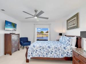 フォートマイヤーズにあるRelax at Lake Breeze 4BR Fort Myers Getawayのベッドルーム1室(ベッド1台、青い椅子、窓付)