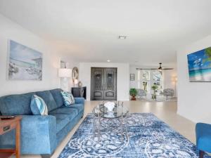 フォートマイヤーズにあるRelax at Lake Breeze 4BR Fort Myers Getawayの青いソファとテーブルのあるリビングルーム