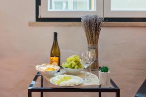 a table with a bottle of wine and bowls of fruit at Sapalinho Retreat - By Y Concept in Setúbal