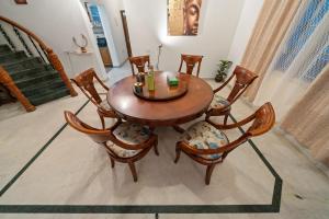 a wooden table and chairs in a room at Urban Escape 4BHK Luxury Villa & Sunflower Skyline 2BHK Penthouse By Spacez in Bangalore
