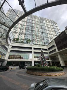 a christmas tree in front of a large building at 2BR Condo in Makati- Good for 6! in Manila