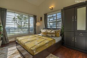 a bedroom with a bed and a large window at EKOSTAY - Skyfall Cloud 9 Villa in Ooty