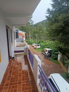 a balcony of a house with a view of a yard at Osprey individual Cottage in Ooty
