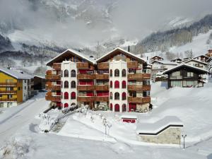 un gran edificio en la nieve con nieve en Château 15, en Leukerbad