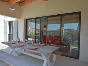 Una mesa de comedor en una habitación con paredes de cristal. en Villa in Malaucène with Heated Pool, en Malaucène