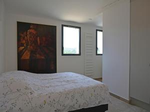 Un dormitorio con una cama y un cuadro en la pared. en Villa in Malaucène with Heated Pool, en Malaucène