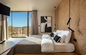 a bedroom with a large bed and a large window at Villa bOX by Villas Guide in Brajkovići +23 photos