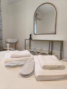two towels sitting on a bed with a mirror at Sole Apartment Xanthi in Xanthi