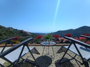 a table and chairs on a balcony with flowers at La Casa Col Portico in Leivi