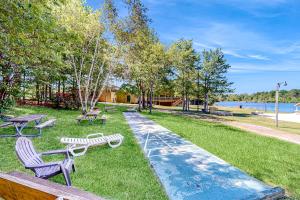 a park with benches and tables and a lake at Pocono Waterside Escape in Tobyhanna