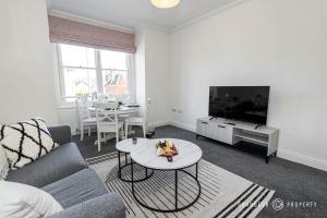 a living room with a couch and a table at The Westborough Nook by Grandeur Property in Wimborne Minster