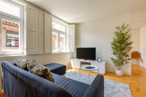 ポルトにあるMagnolia 5 Luxury with AC Metro Downtown Portoのソファとテレビのあるリビングルーム
