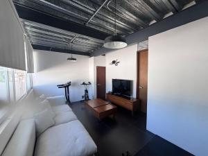 a living room with a couch and a tv at Xalapa Monte Novo Contemporary House in Xalapa