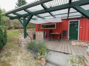 a pergola over a deck with a red house at Retreat with Private Garden in Güntersberge