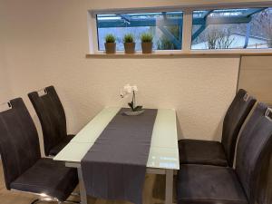 a dining room table with chairs and a table with flowers on it at Retreat with Private Garden in Güntersberge