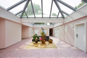 a conservatory with a glass ceiling and a living room at Hotel Weiss in Angermünde