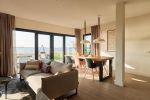 a living room with a couch and a table at Dutchen Baayvilla's in Lauwersoog