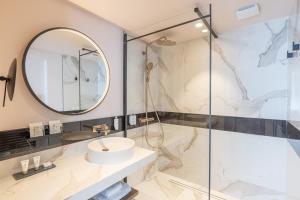 a bathroom with a sink and a mirror at Le Riviera - Hôtel Restaurant & Spa - Ex Golden Tulip Aix les bains in Aix-les-Bains