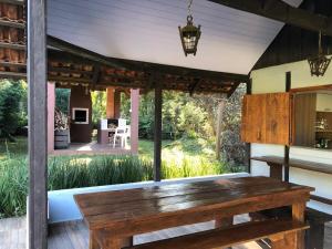 a wooden bench on a patio with a table at Chalé com Vista para Vinhedo e Natureza in Guarapuava