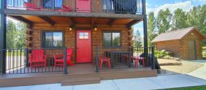 a cabin with red chairs and a table on a deck at SkyWater Cabins in Hamilton