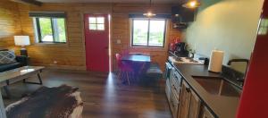 a kitchen with a red door and a living room at SkyWater Cabins in Hamilton