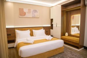 Un dormitorio con una cama grande con toallas. en Shaden Inn شادن ان, en Najrán