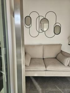 Un sofá en una habitación con dos espejos en la pared. en NALI Apartment 2, en Civitanova Marche