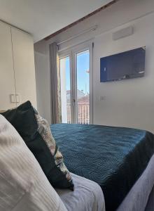 Un dormitorio con una cama y un televisor en la pared. en NALI Apartment 2, en Civitanova Marche