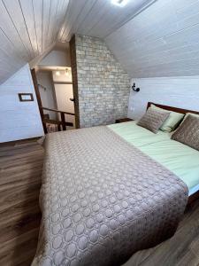a large bed in a room with a brick wall at Червона гора in Irshava