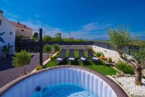 a backyard with a swimming pool and a patio with chairs at Villa Romana in Bibinje