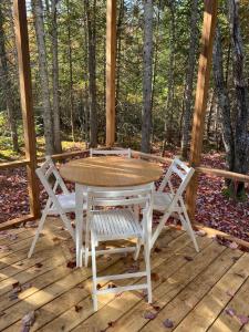 a table and two chairs on a wooden deck at Country Comfort - Woods & RiverLa Sittelle in Saint-Raymond