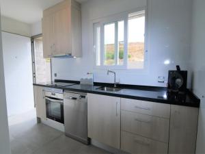 eine weiße Küche mit Spüle und Herd in der Unterkunft Estancia Rojales con Jardín in Rojales