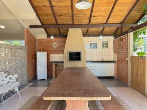 uma grande cozinha com uma mesa de madeira no meio em MORADA ILHA PARAISO em Florianópolis