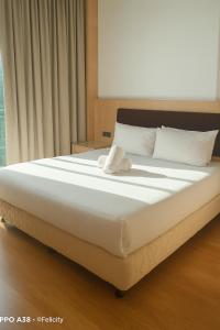 a large white bed in a room with a window at Imperial Suites Apartment Kuching in Kuching