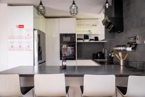 a kitchen with a table with white chairs in it at Holiday House Valaliky in Valaliky