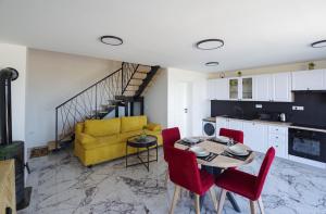 a kitchen and living room with a table and red chairs at Villa Romana in Bibinje