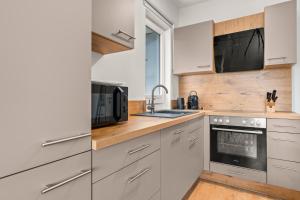 a kitchen with white cabinets and a sink at CEDAR - Zentral - Flexbetten - Switch - 15min Willingen in Brilon