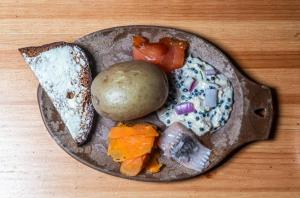 un piatto di cibo su un tavolo di legno di Peurakaltio Arctic Retreat a Muonio Altre 48 foto