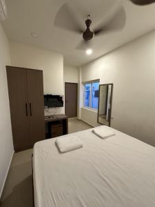 a bedroom with a bed and a ceiling fan at Elixir residency in Puducherry