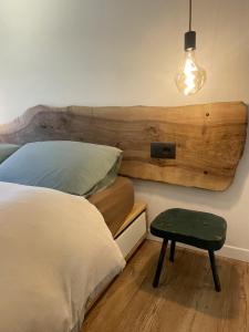 a bedroom with a bed with a wooden headboard and a table at Alpine Hideaway in a 1700's Borgata in Bussoleno +32 photos
